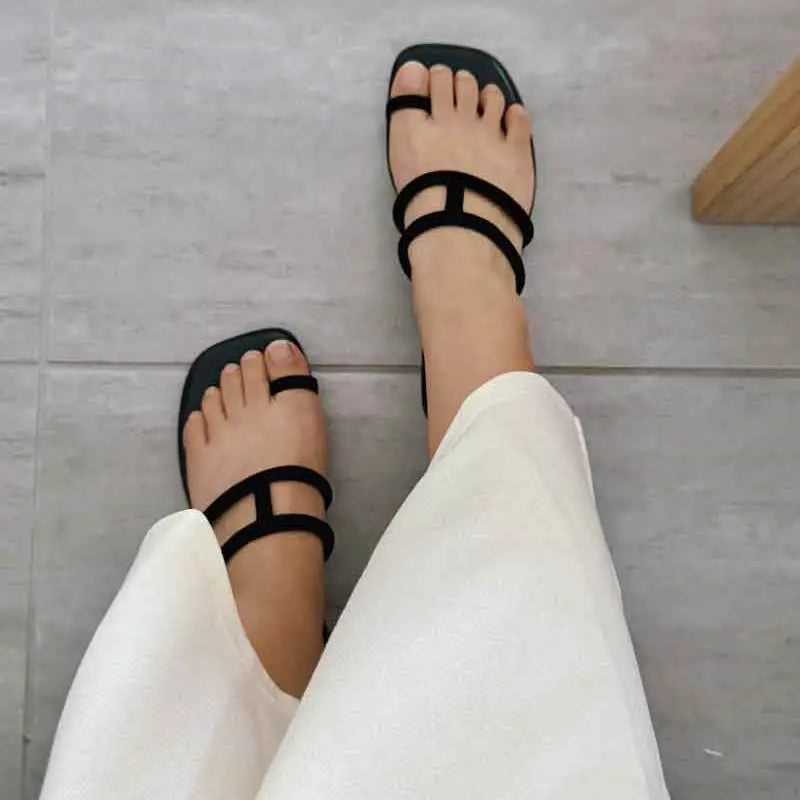 Model wearing women's sandals in black slides style