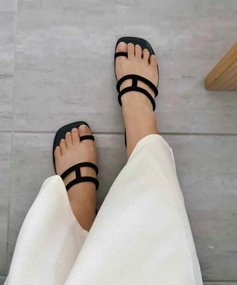 Model wearing women&#39;s sandals in black slides style