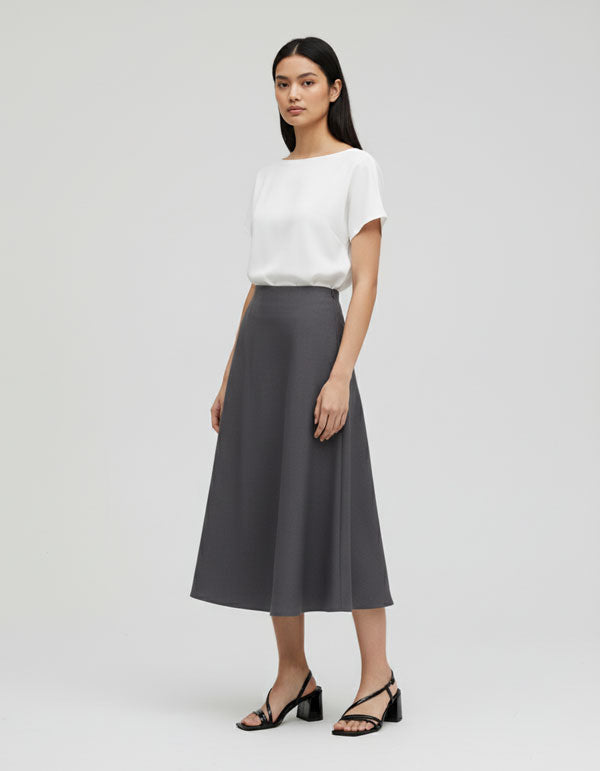 Model wearing black strappy sandals pair with mid-skirt