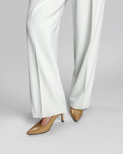 White pants with beige high-heeled shoes on a gray background