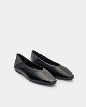 Side view of black flat shoes on a light  background