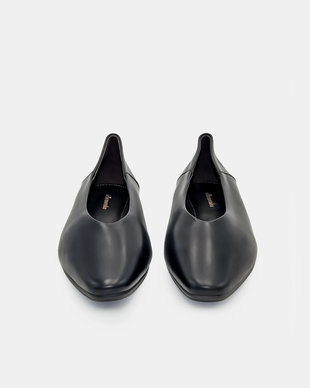 Pair of black flat shoes on a light gray background