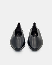 Pair of black flat shoes on a light gray background