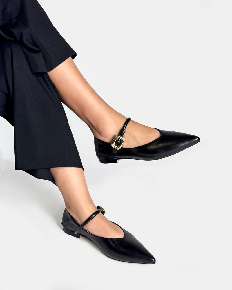 Black pointed-toe Mary Jane flats with a gold buckle strap