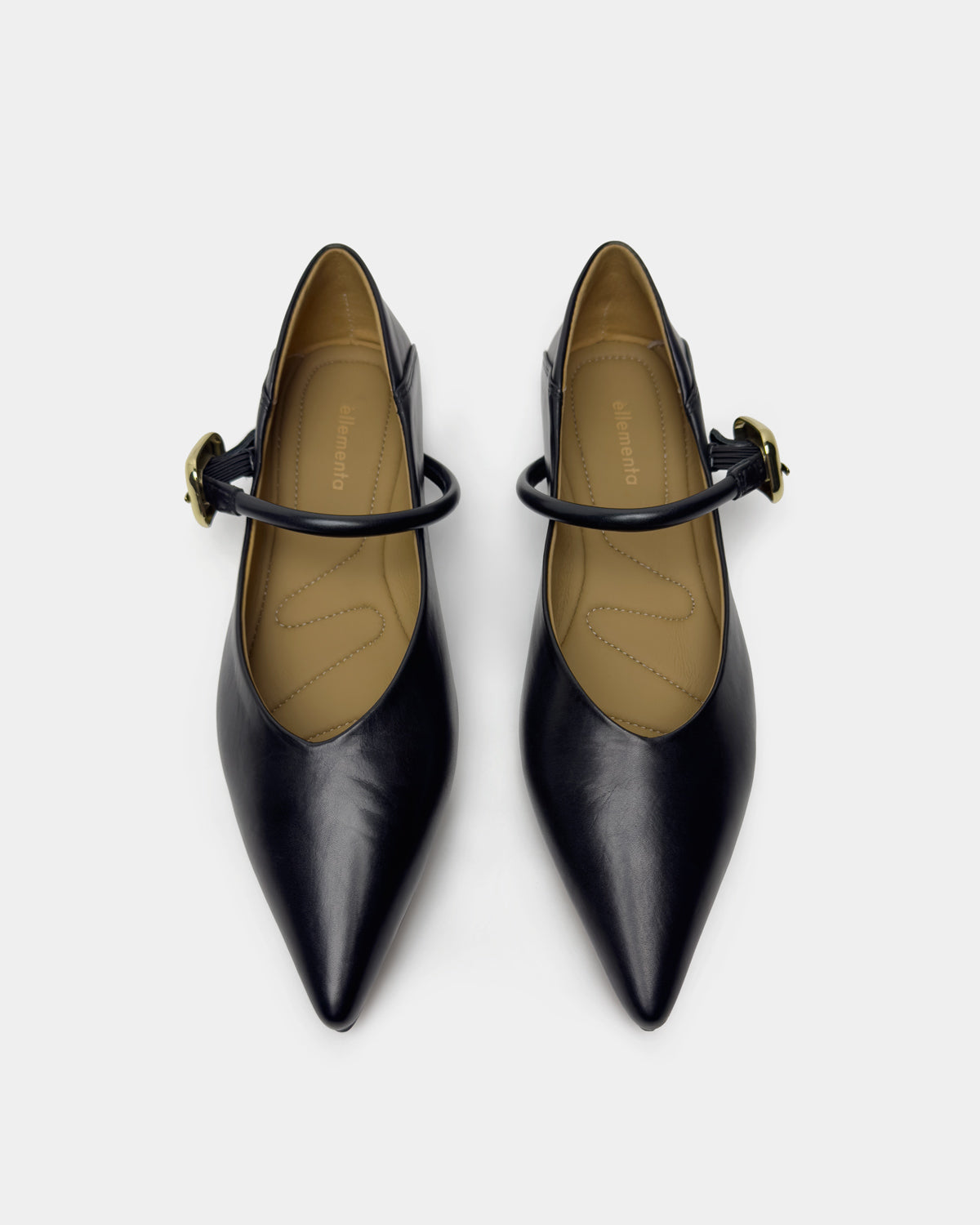 A pair of black leather pointed-toe Mary Jane pumps with gold-tone buckle straps, shown from a top-down view on a light gray background.