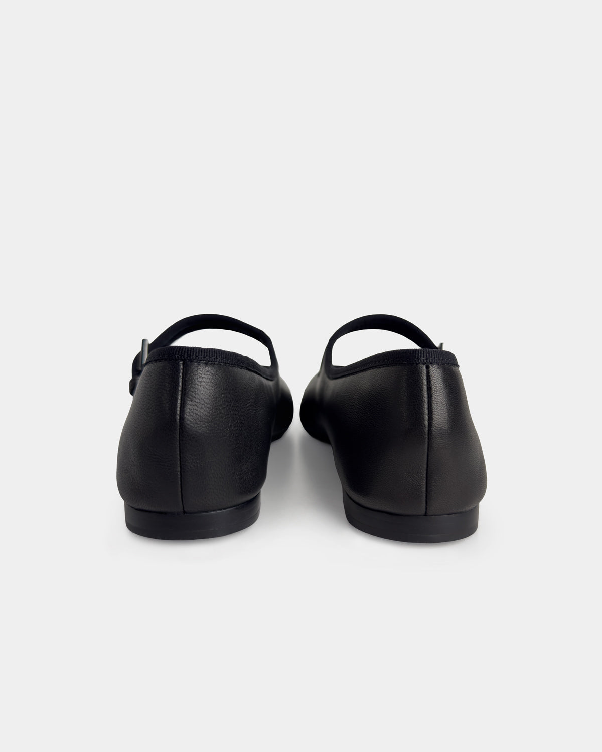 A pair of black leather Mary Jane ballet flats shown from the back against a light gray background.