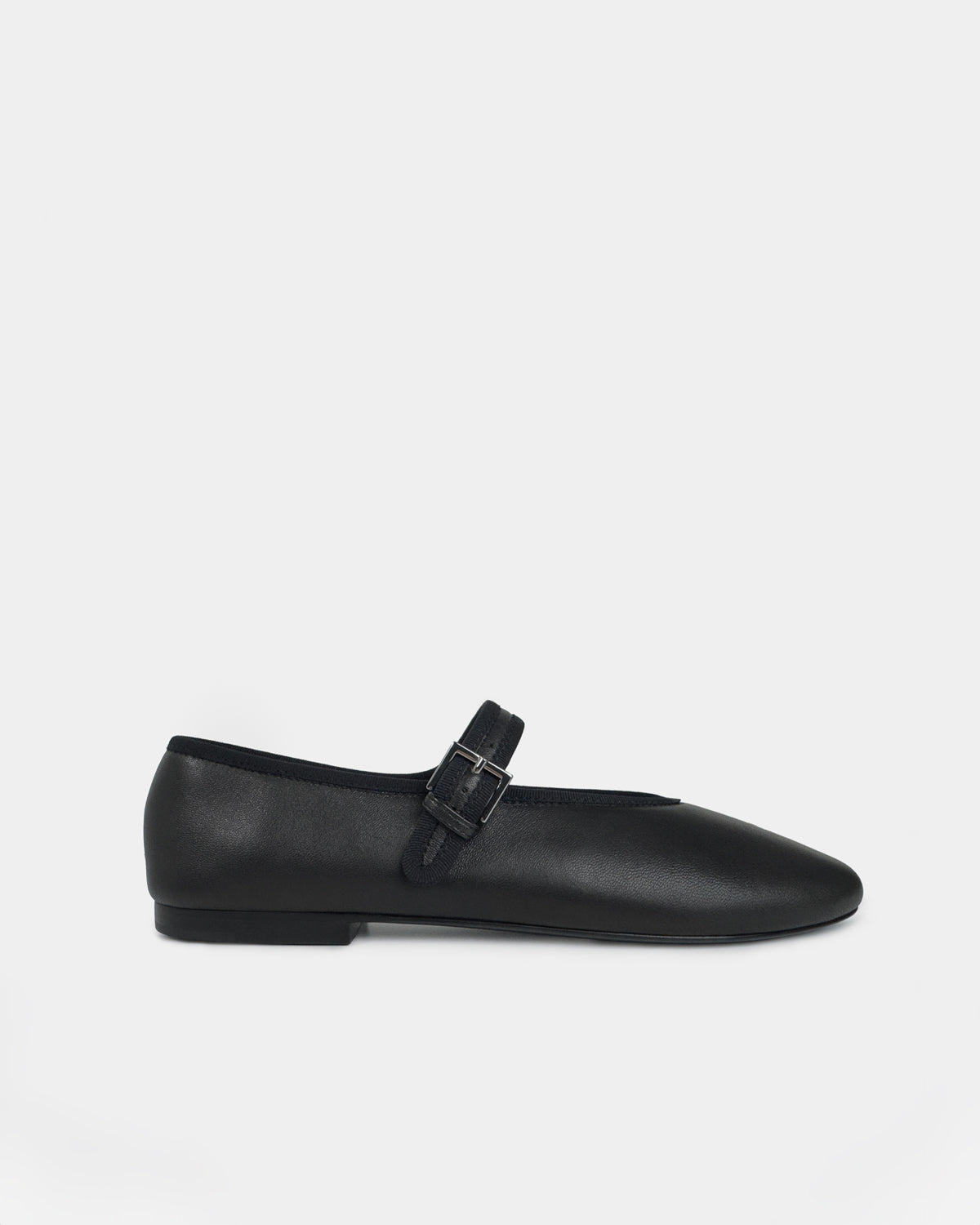 A single black leather Mary Jane ballet flat shoe with a round toe and a small silver buckle, shown in profile against a light gray background.