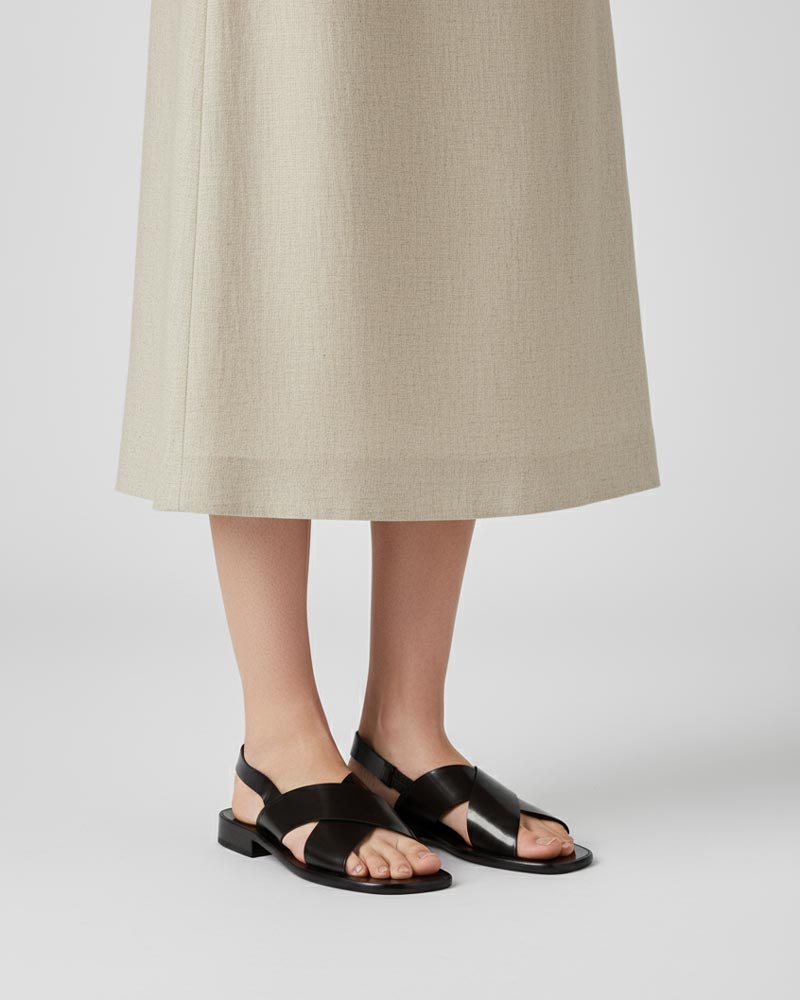 Model wearing black leather slingback sandals