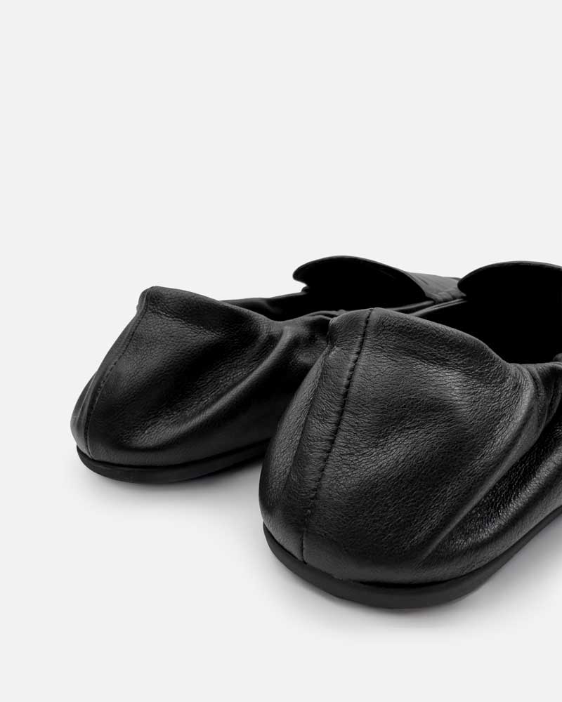Close-up of elasticated back on black loafers for women
