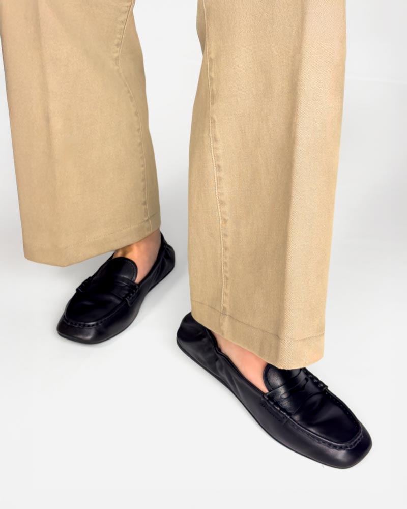 Model styling women's black loafers in soft leather