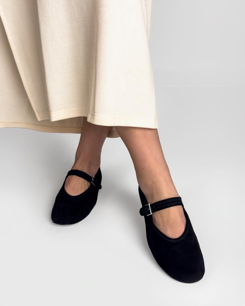 Model styling black suede leather ballet flats with strap