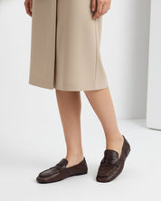 Woman wearing brown slip on loafers in soft leather