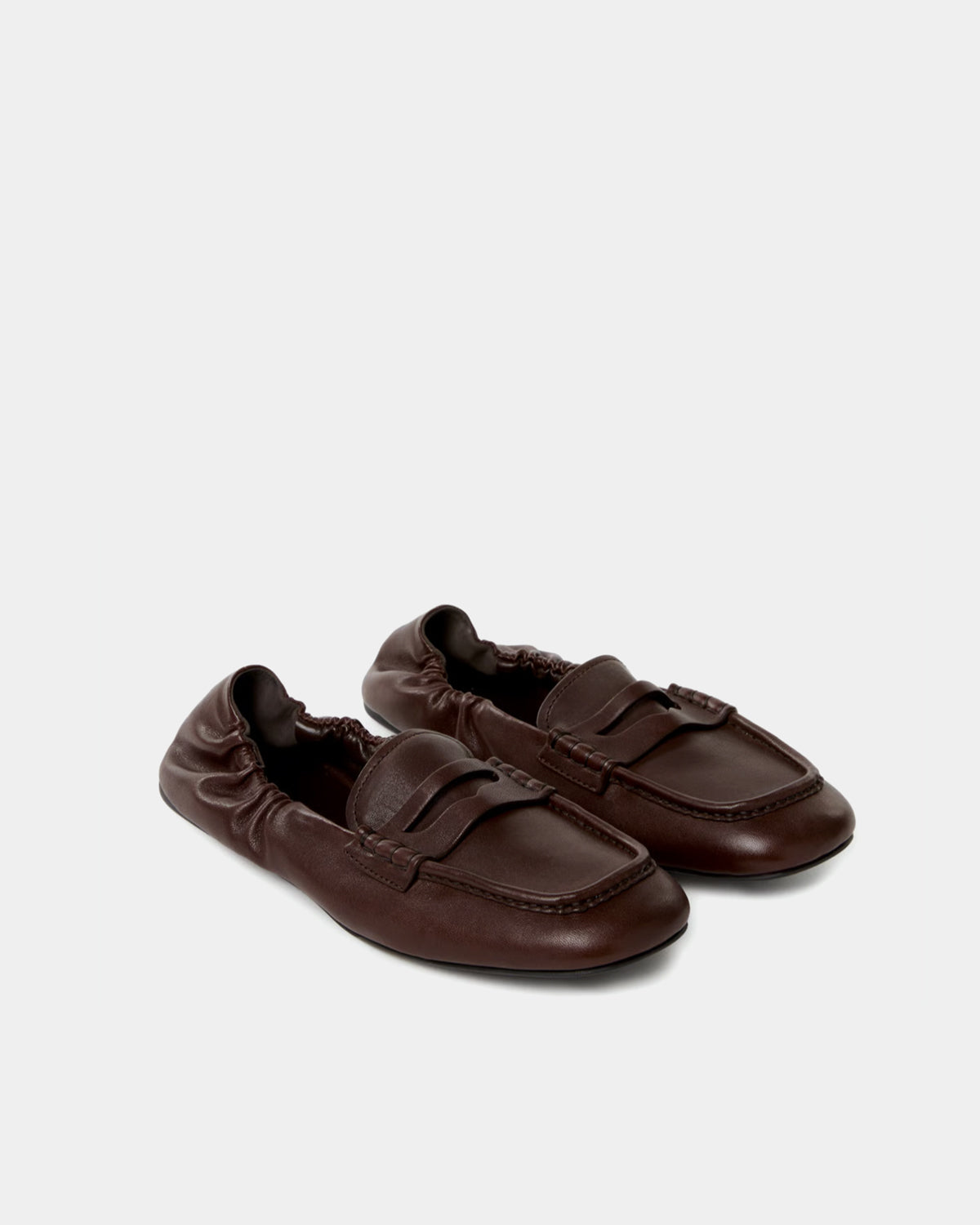 Pair of dark brown loafers on a light gray background