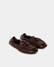 Pair of dark brown loafers on a light gray background