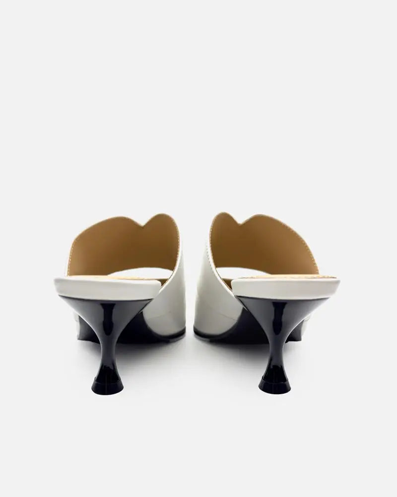 pair of white mules with black kitten heels