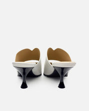 pair of white mules with black kitten heels