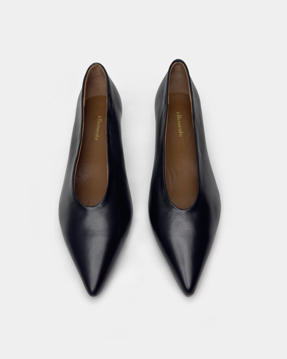 A pair of black leather pointed-toe pumps with a low block heel, shown from a top-down view on a light gray background.
