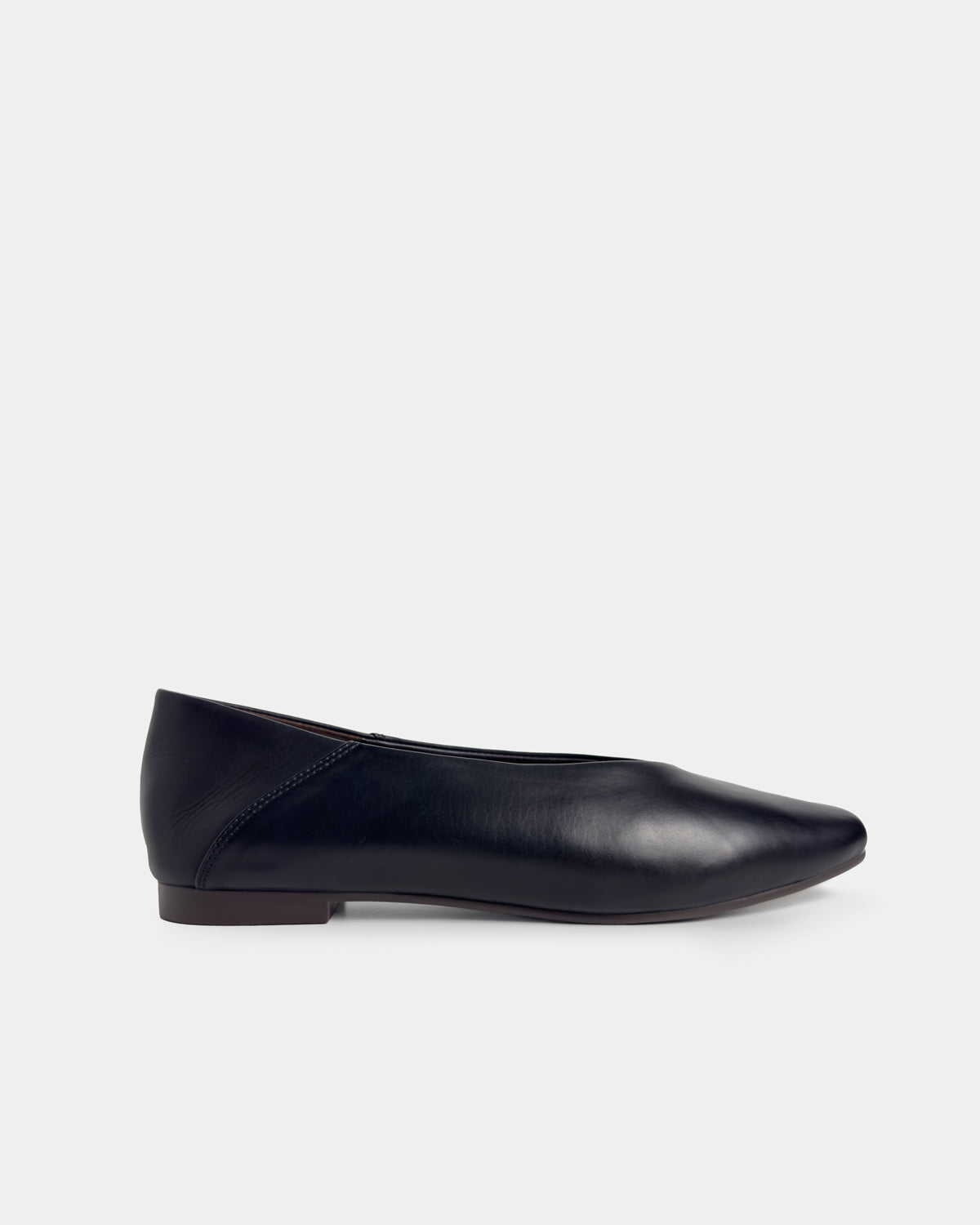 A single black leather flat shoe with a round toe, shown in profile against a light gray background.