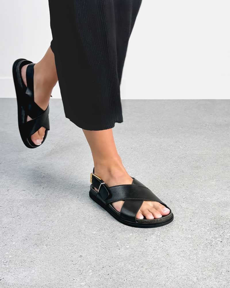 Woman wearing back leather buckle strap sandals 