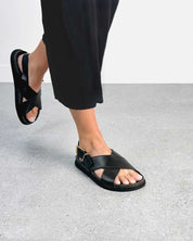 Woman wearing back leather buckle strap sandals 