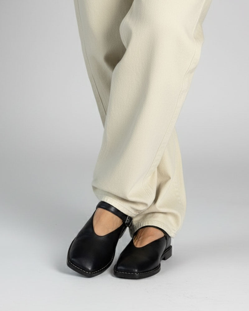 Model wearing Mary Jane Shoes in black leather with casual pants.