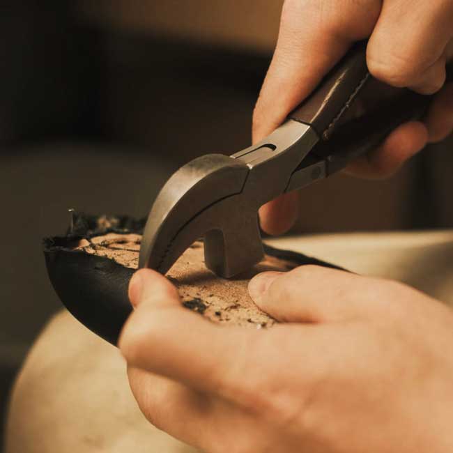 Artisan from ellementa is shaping shoe upper leather to last.