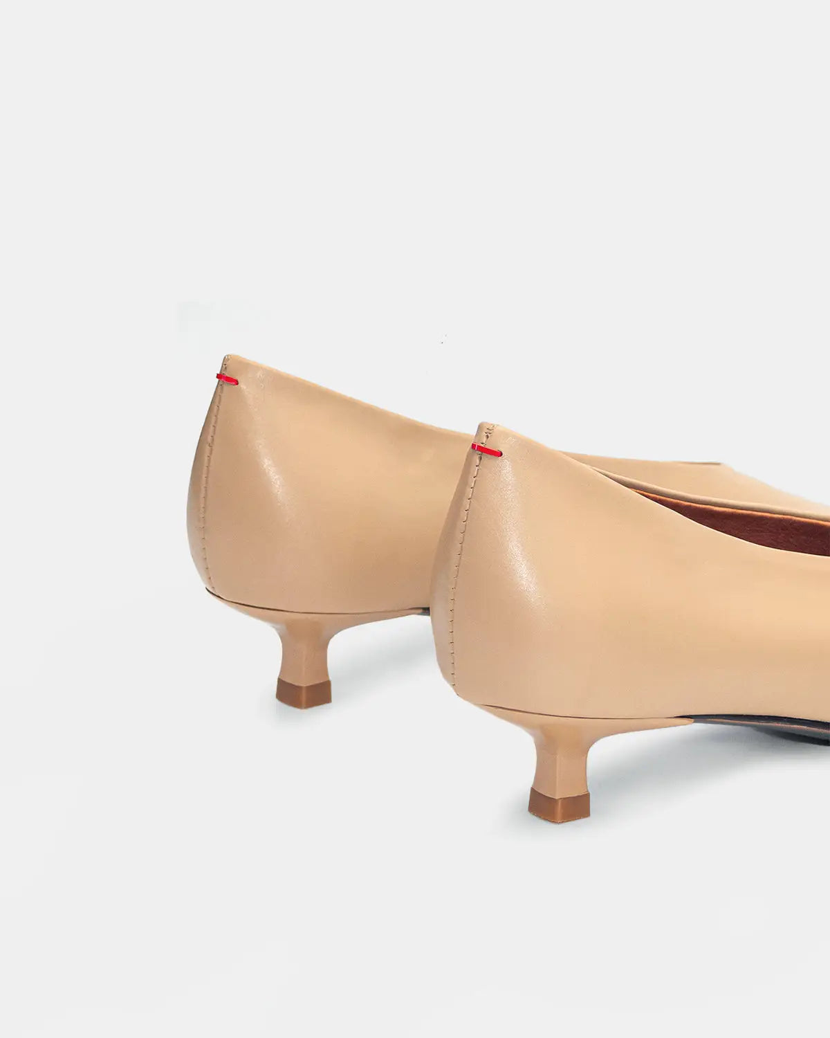 Elegant beige calfskin kitten heel pumps with a pointed toe, perfect as bridal kitten heels or for special occasions