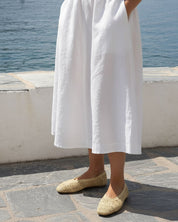 woman wearing natural raffia ballet flats with summer linen outfit