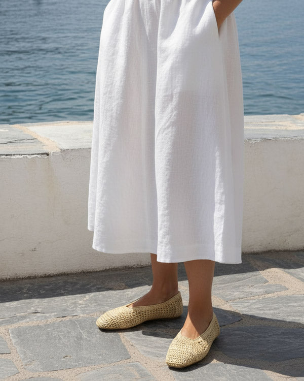 woman wearing natural raffia ballet flats with summer linen outfit